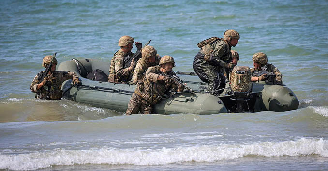 A group of men in camouflage uniforms on a boat. Description generated by AI