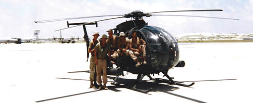 A group of soldiers are sitting on the back of a helicopter. Description generated by AI
