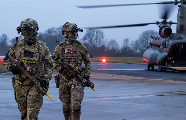 Two soldiers walking on a runway. Description generated by AI