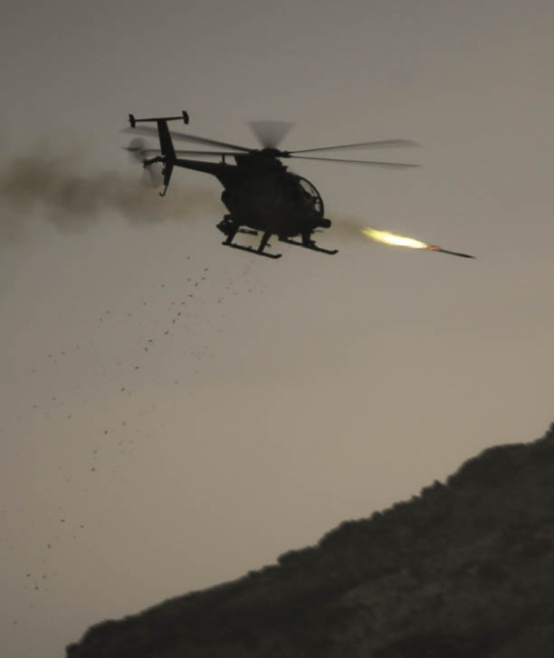 A helicopter is flying over a rocky hill. Description generated by AI