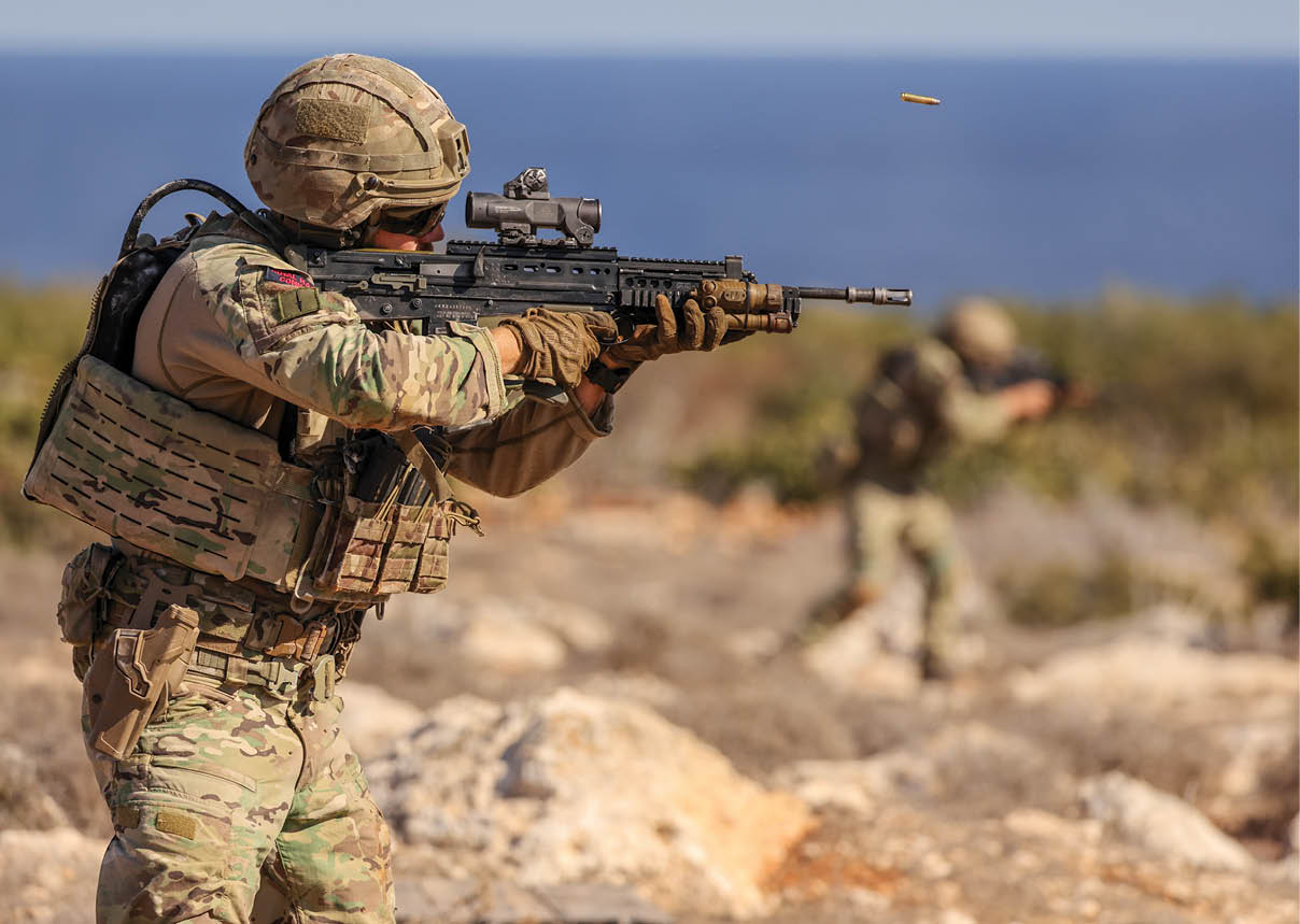 A man in a camouflage uniform holding a gun. Description generated by AI