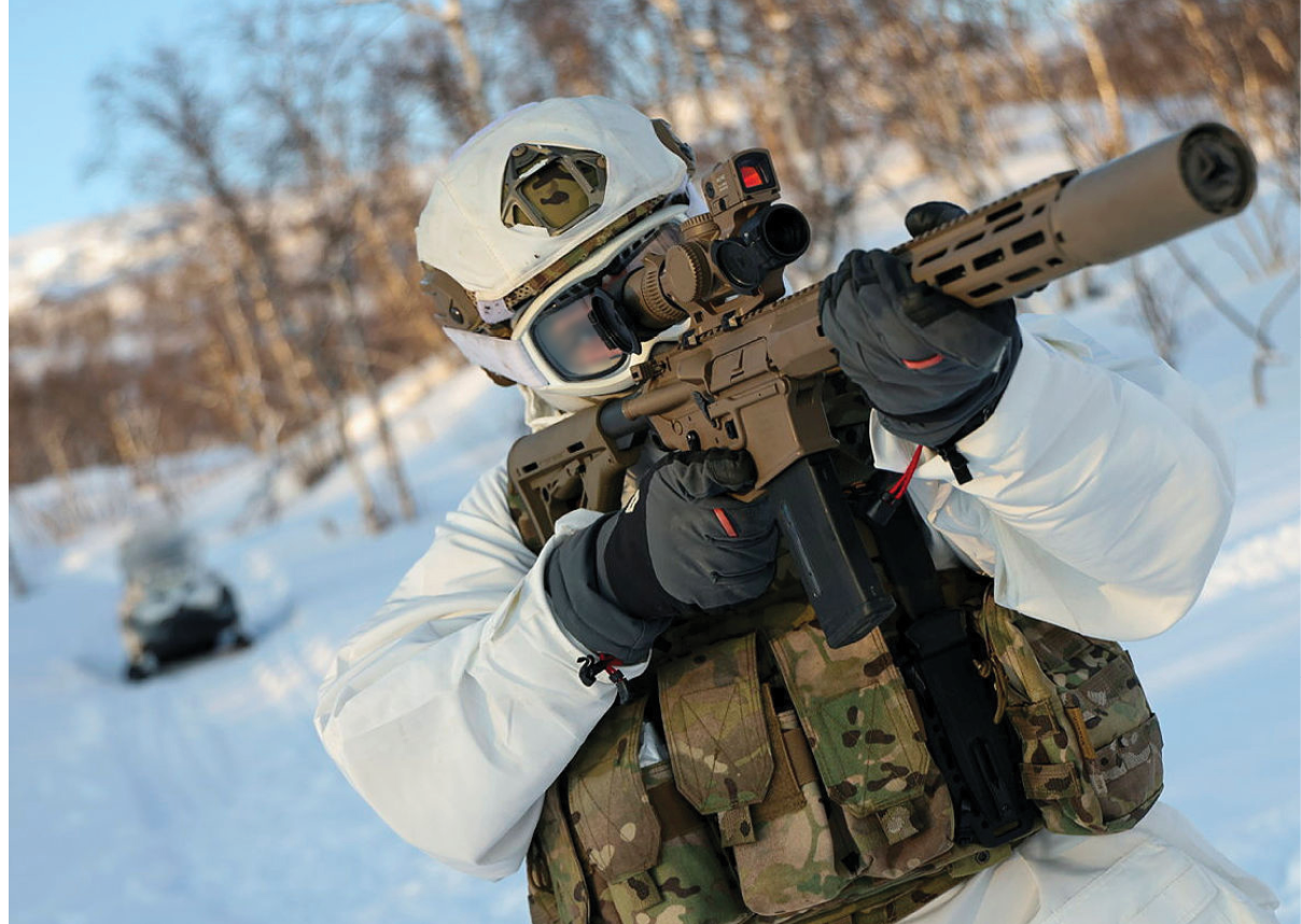 A man in a white and camouflage uniform holding a gun. Description generated by AI