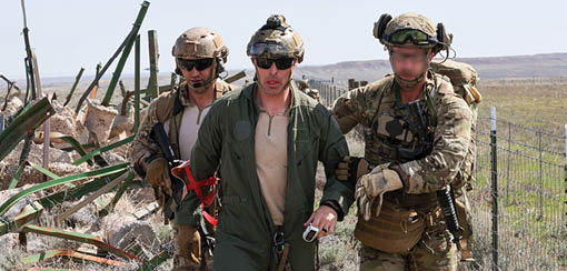 Three men wearing camouflage uniforms and carrying guns. Description generated by AI