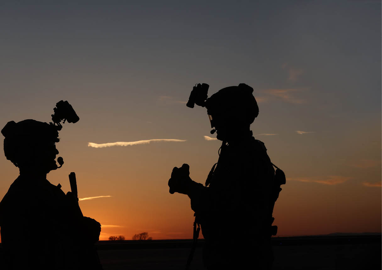 Two people standing in front of a sunset. Description generated by AI