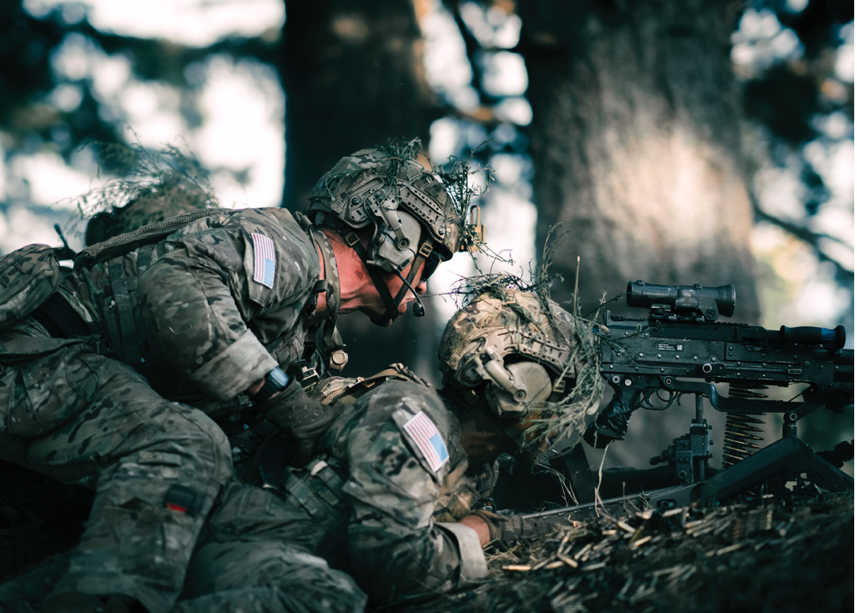 Two men in camouflage uniforms are playing with a toy gun. Description generated by AI