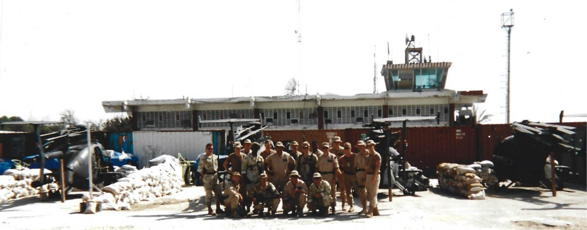 A green military vehicle is parked in a dirt lot. AI generated content