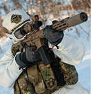 A person in a white snow suit holding a gun. Description generated by AI