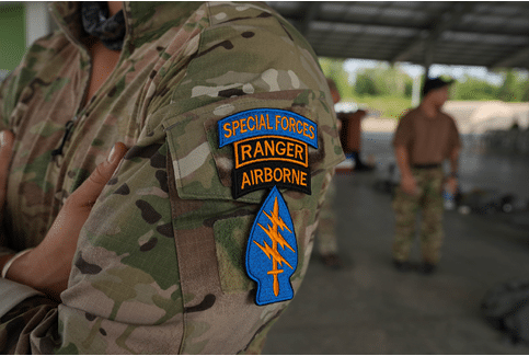 A person wearing a camouflage jacket with a Special Forces Ranger Airborne patch. AI generated content