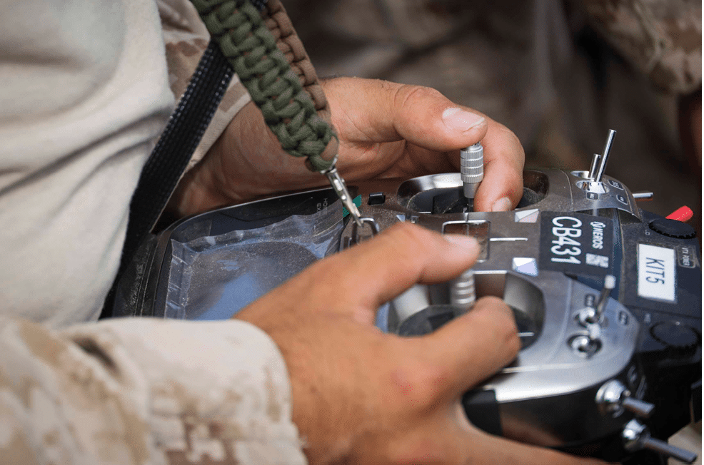 A person is adjusting controls on a remote device with their hands. Description generated by AI