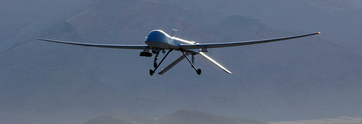 A drone with extended wings is flying against a backdrop of mountains. Description generated by AI