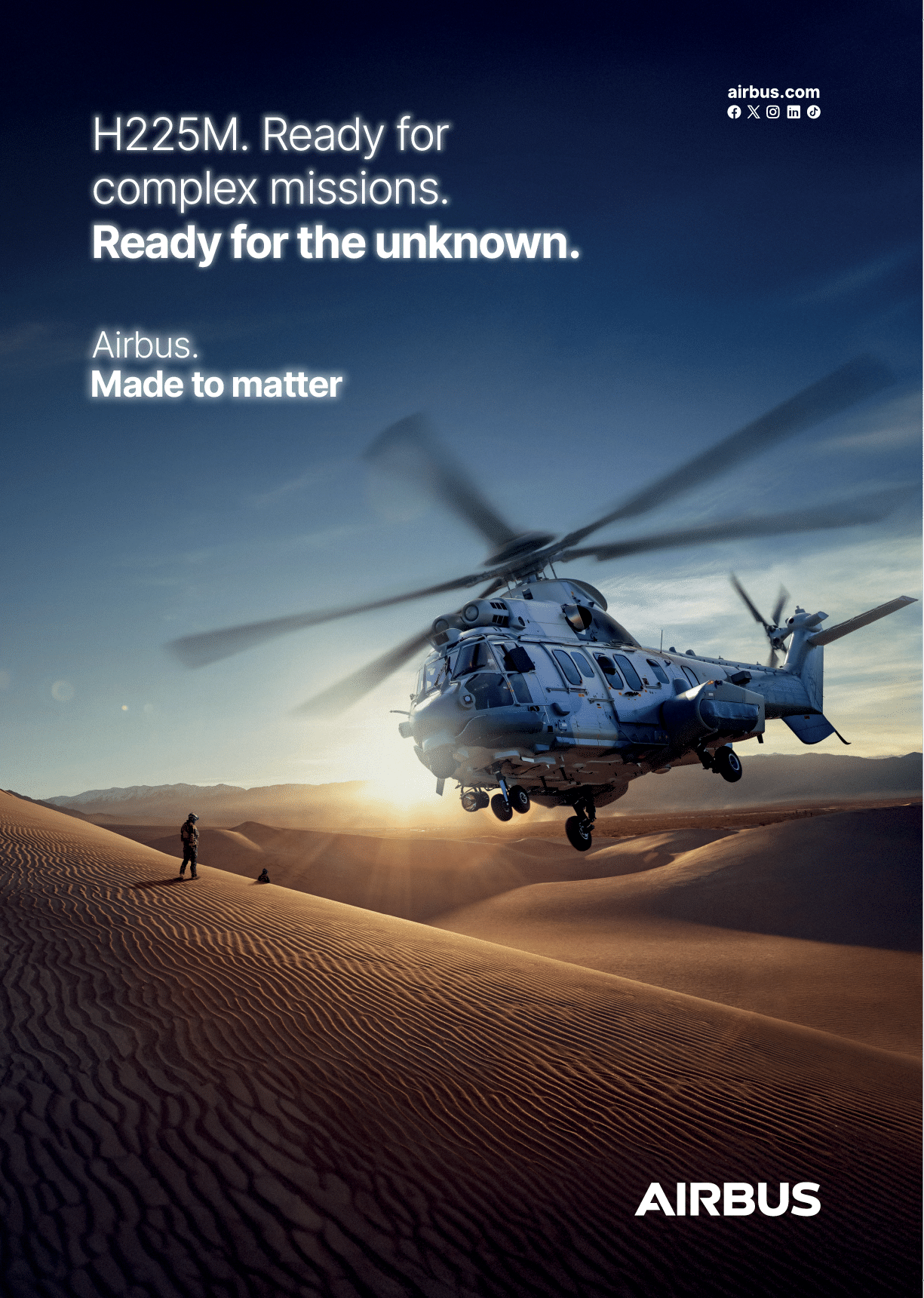 A helicopter hovers above sand dunes at sunset with a person standing on the dunes watching it, accompanied by text promoting the Airbus H225M helicopter for complex missions. Description generated by AI
