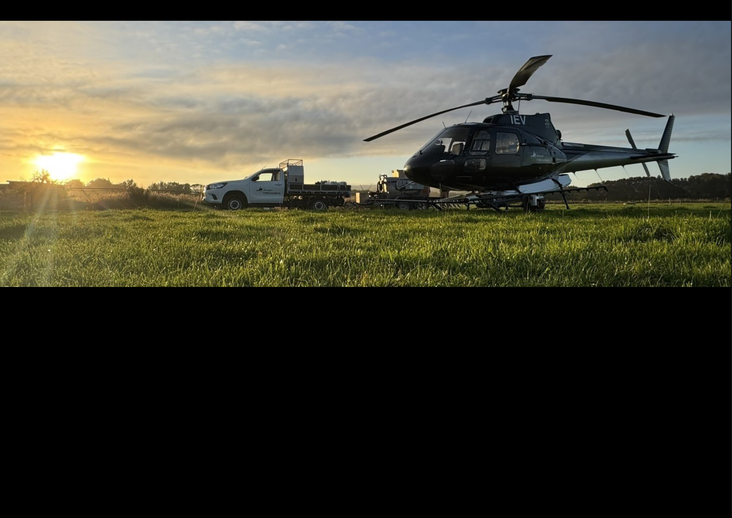 A helicopter is parked in a grassy field with a truck nearby. AI generated content