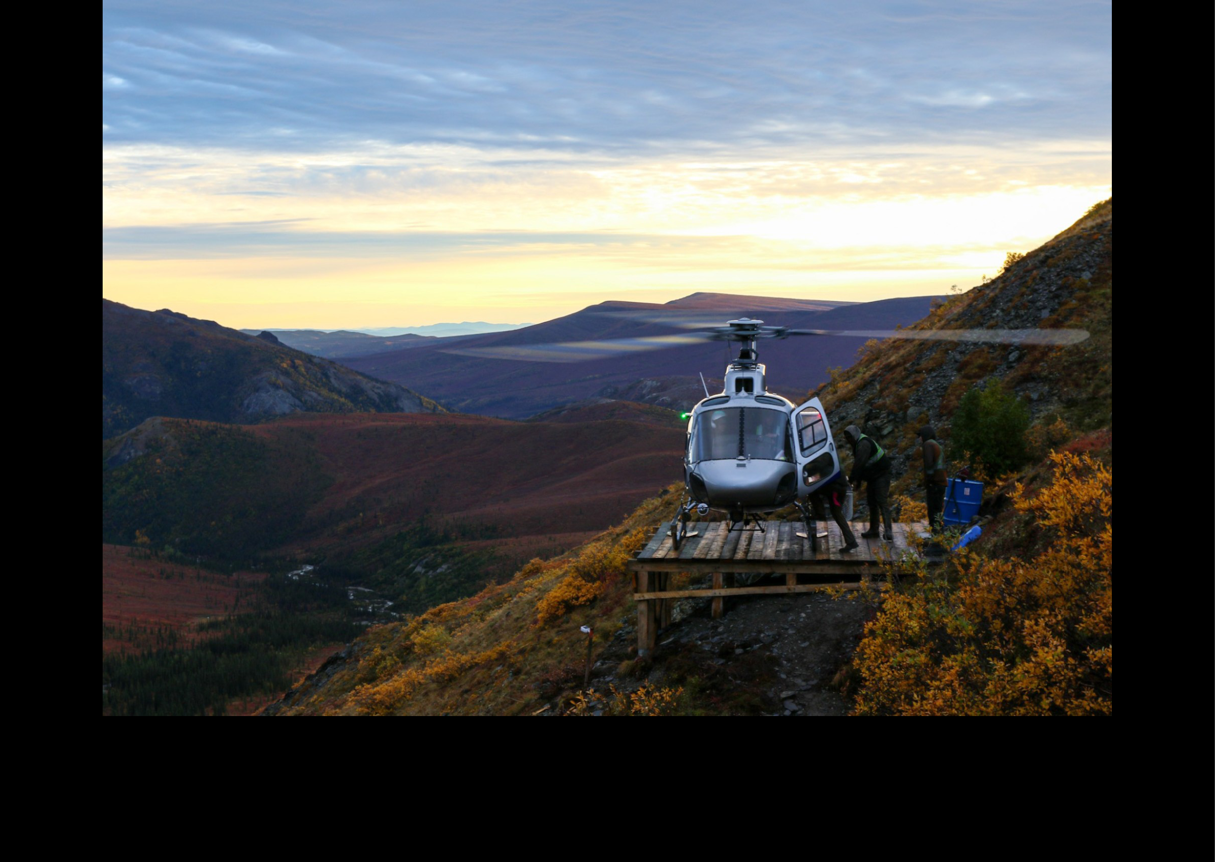 A helicopter is parked on a wooden platform in a mountainous area. AI generated content