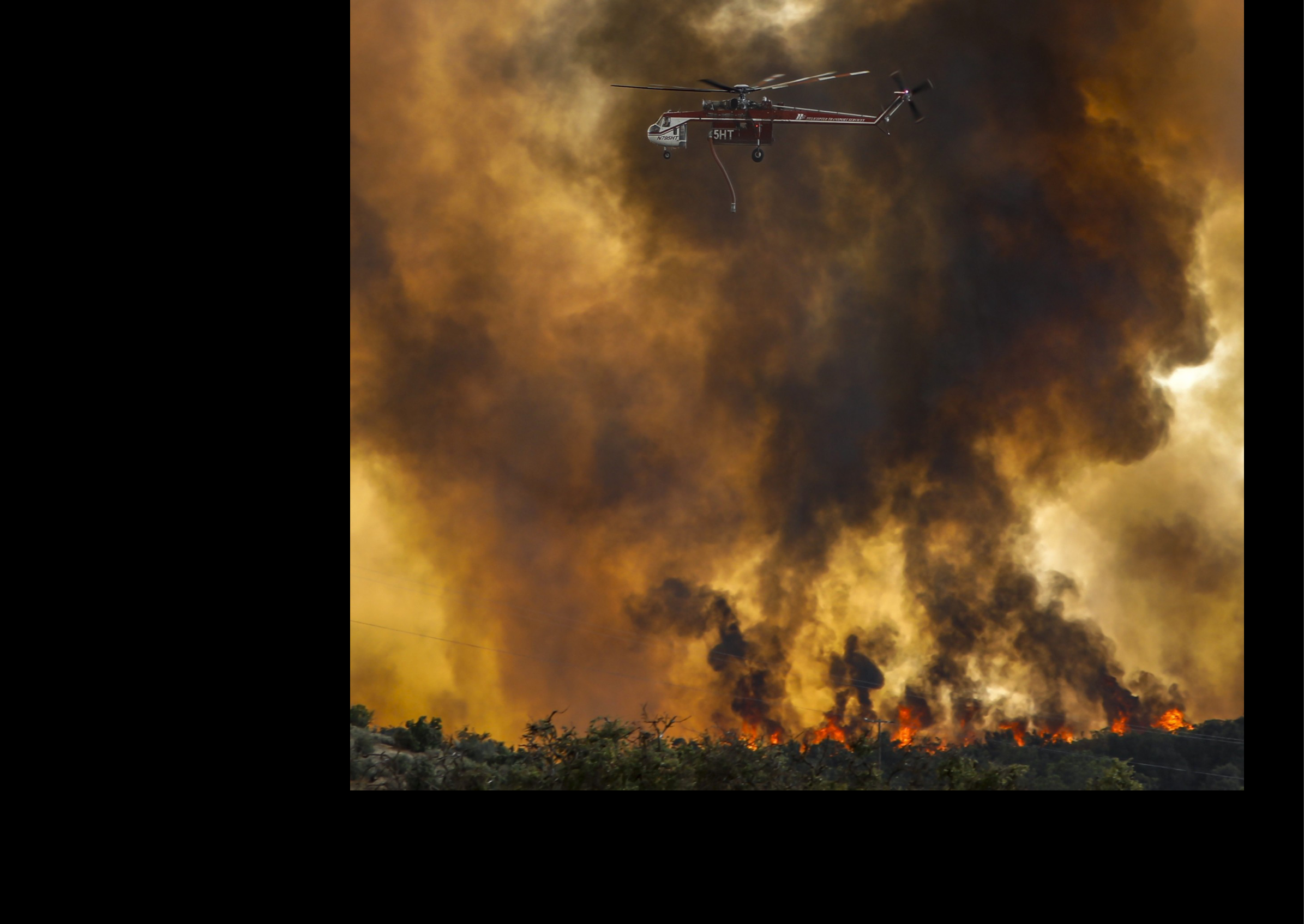 A red and white helicopter is flying over a forest fire. AI generated content
