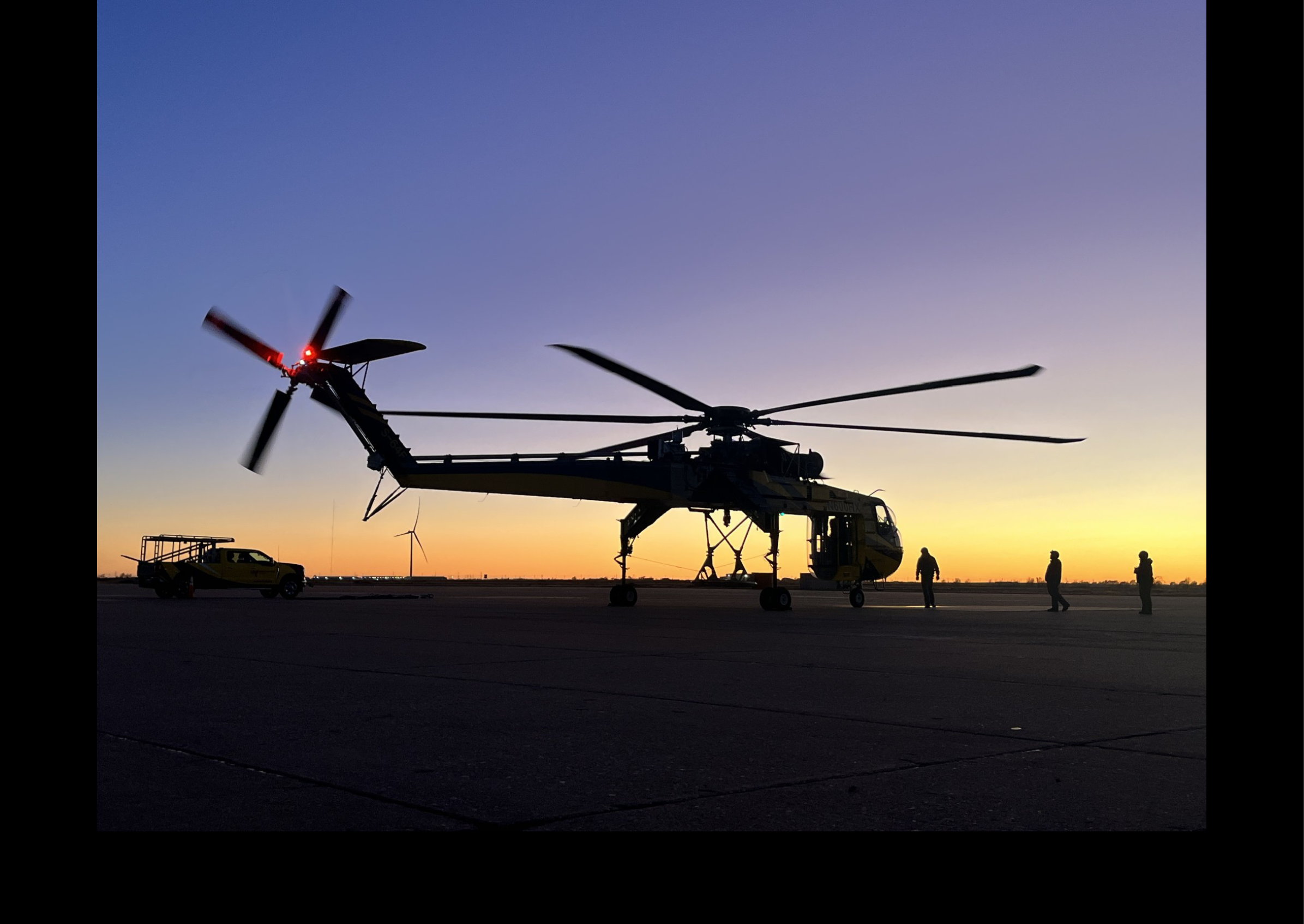 A large helicopter with two rotors is parked on a runway. AI generated content