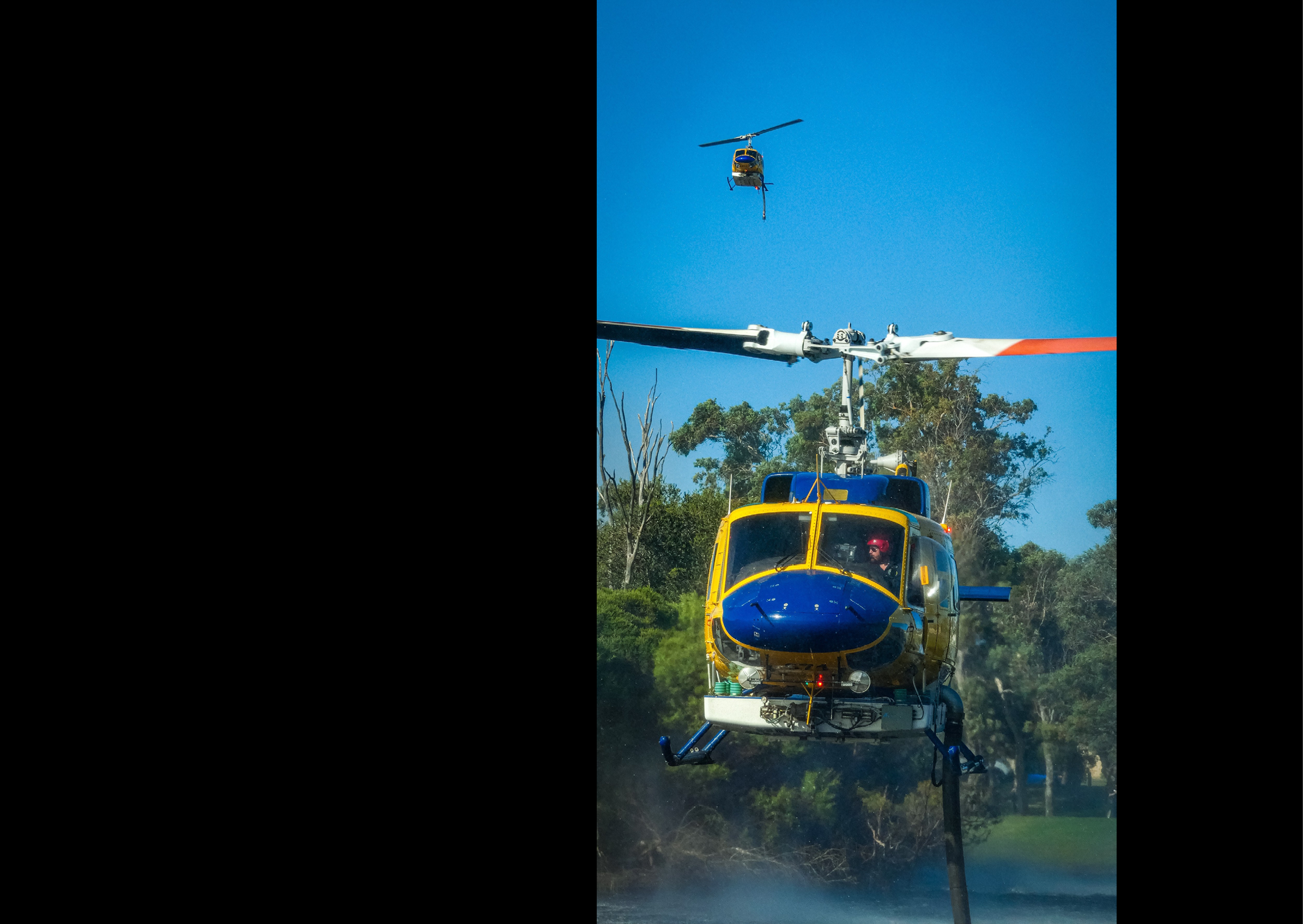 A blue and yellow helicopter is flying in the air with a person inside. AI generated content