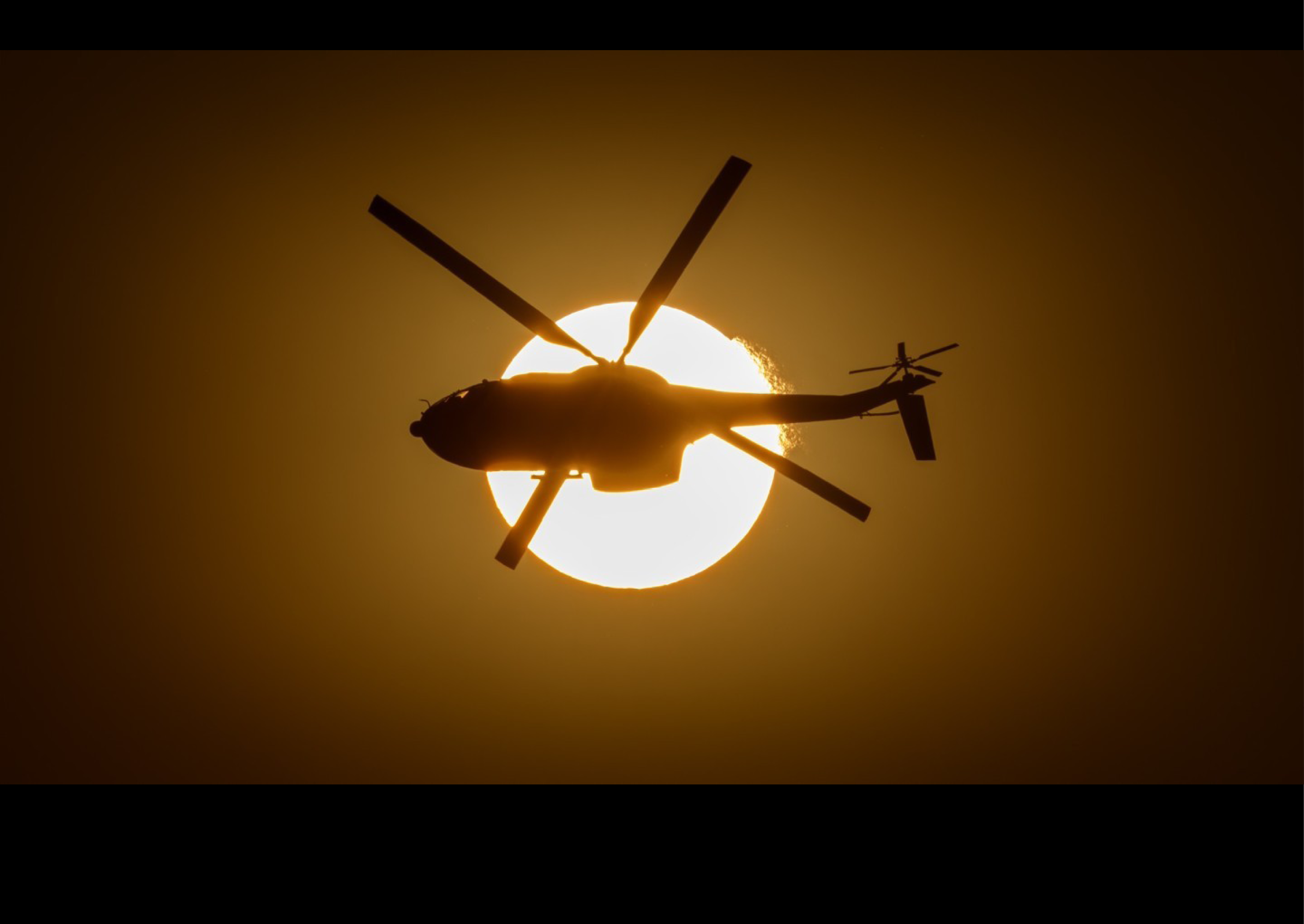 A helicopter is flying in the sky with the sun in the background. AI generated content