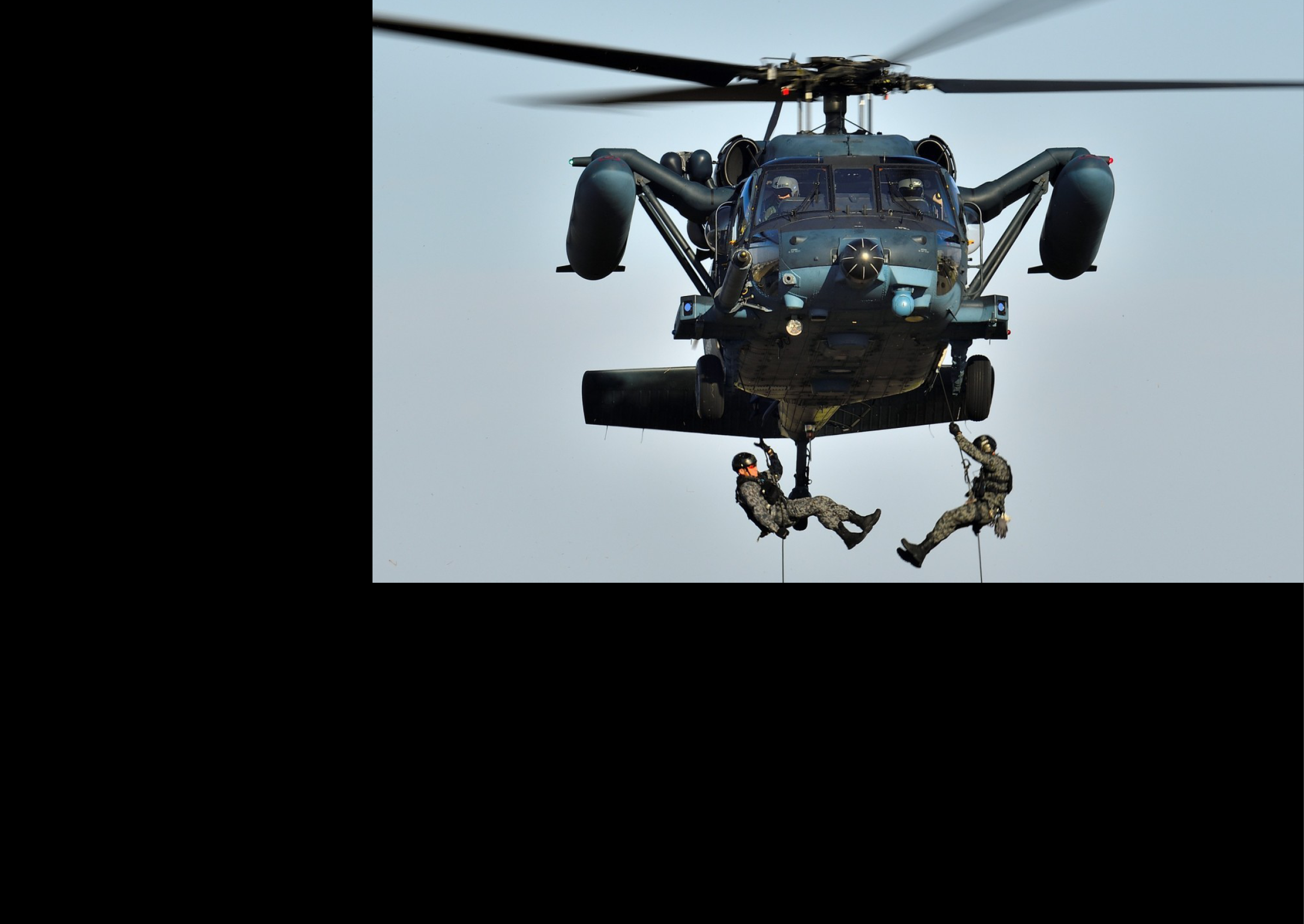Two men are hanging from a helicopter, one is holding onto a rope while the other is holding onto a man. AI generated content