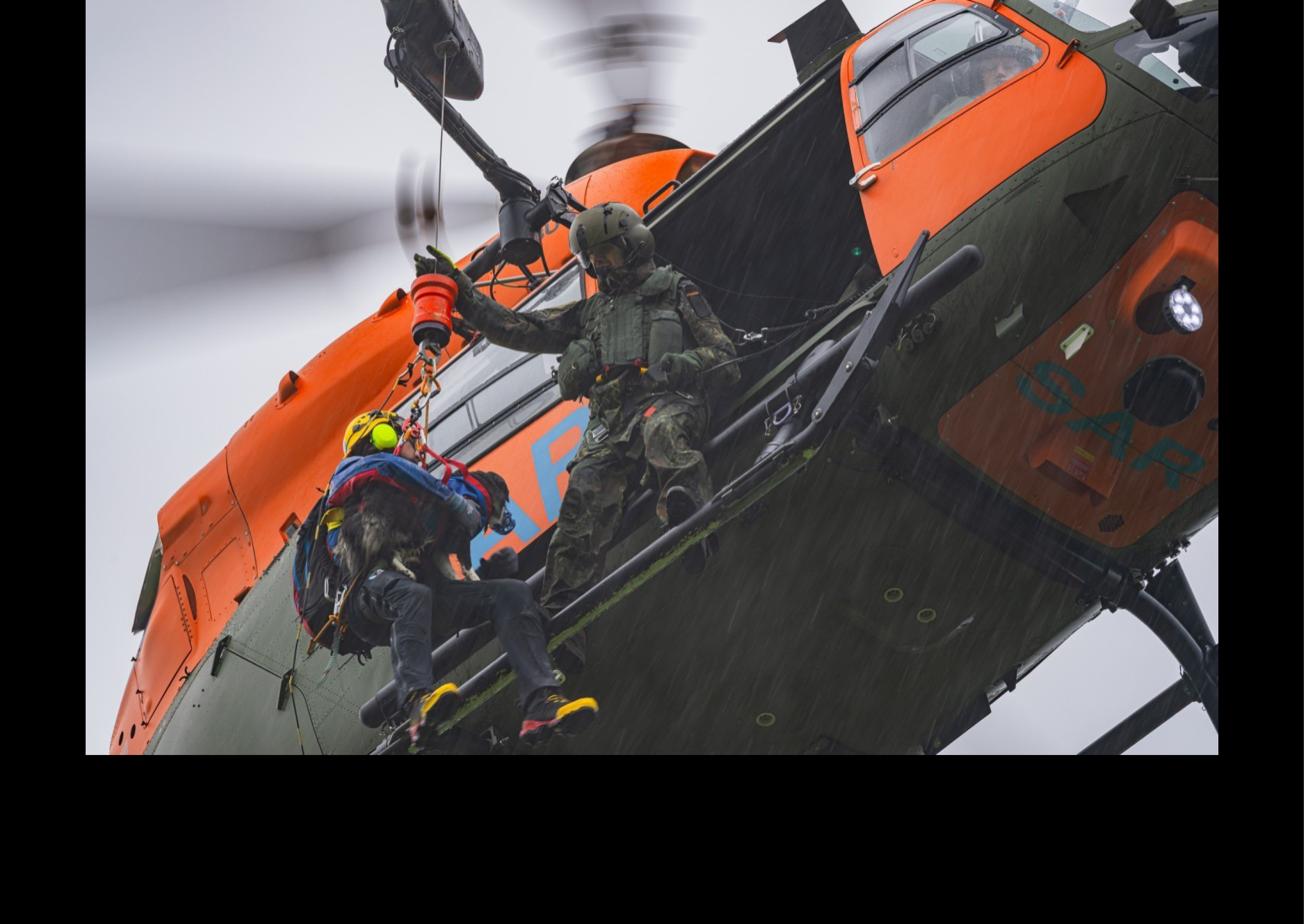 A person is being lifted by a helicopter, wearing a backpack. AI generated content