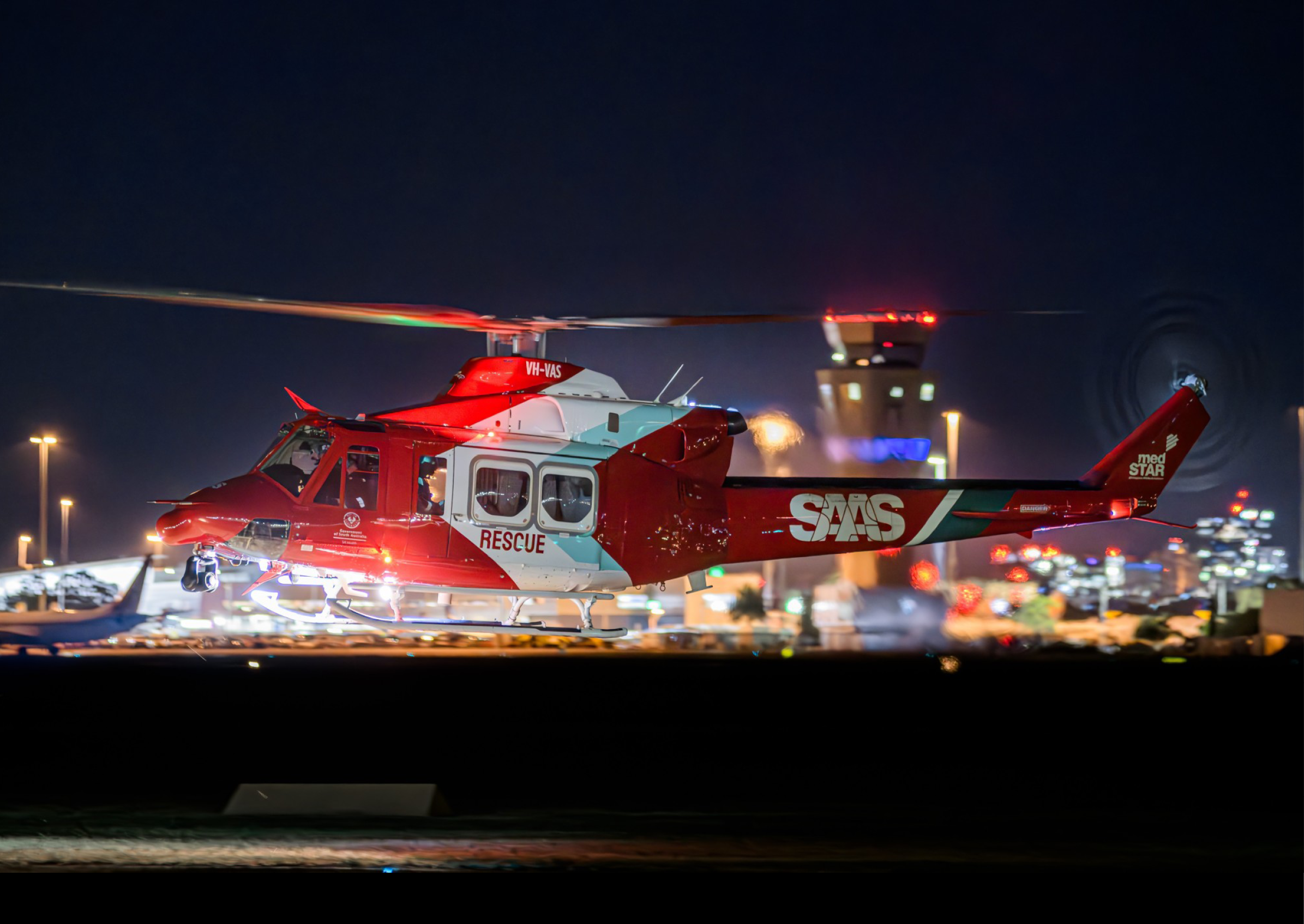 A red and white helicopter is on the ground with its landing gear down. AI generated content