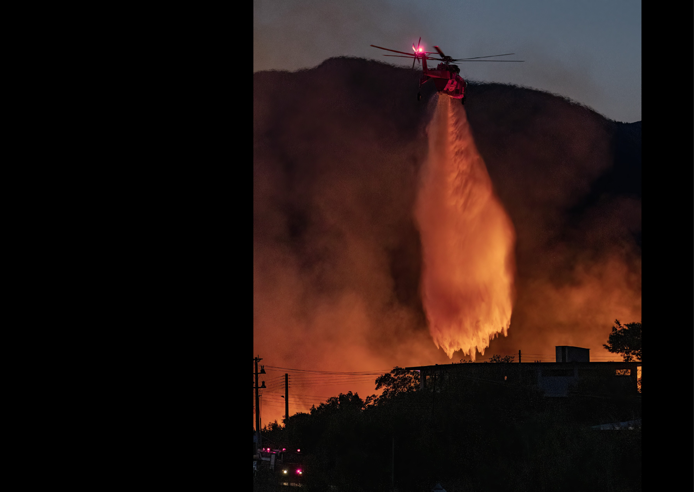 A helicopter is flying over a fire, spraying water to extinguish it. AI generated content