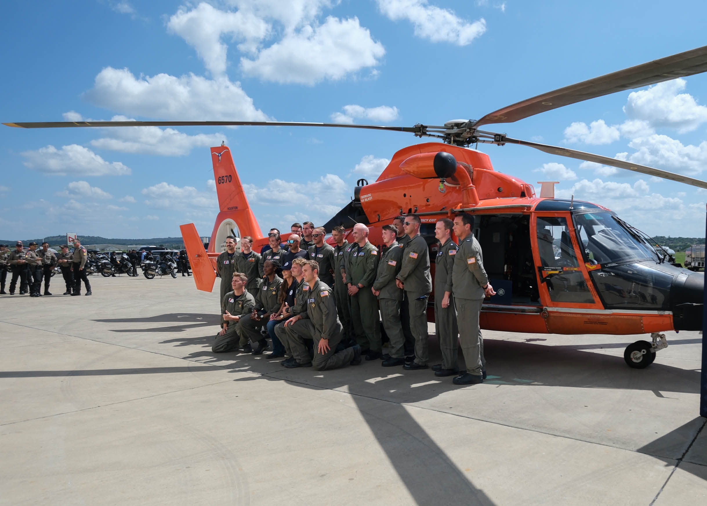 Department of Homeland Security Secretary Kristi Noem poses for a group photo with personnel from Coast Guard Air Stations Corpus Christi and Houston, July 11, 2025, in Kerrville, Texas. Both air stations responded to a request for Coast Guard assistance in response to the catastrophic flash flooding on July 4 near Kerrville, rescuing scores in the storm's wake. (U.S. Coast Guard photo by Petty Officer 3rd Class Carmen Caver)