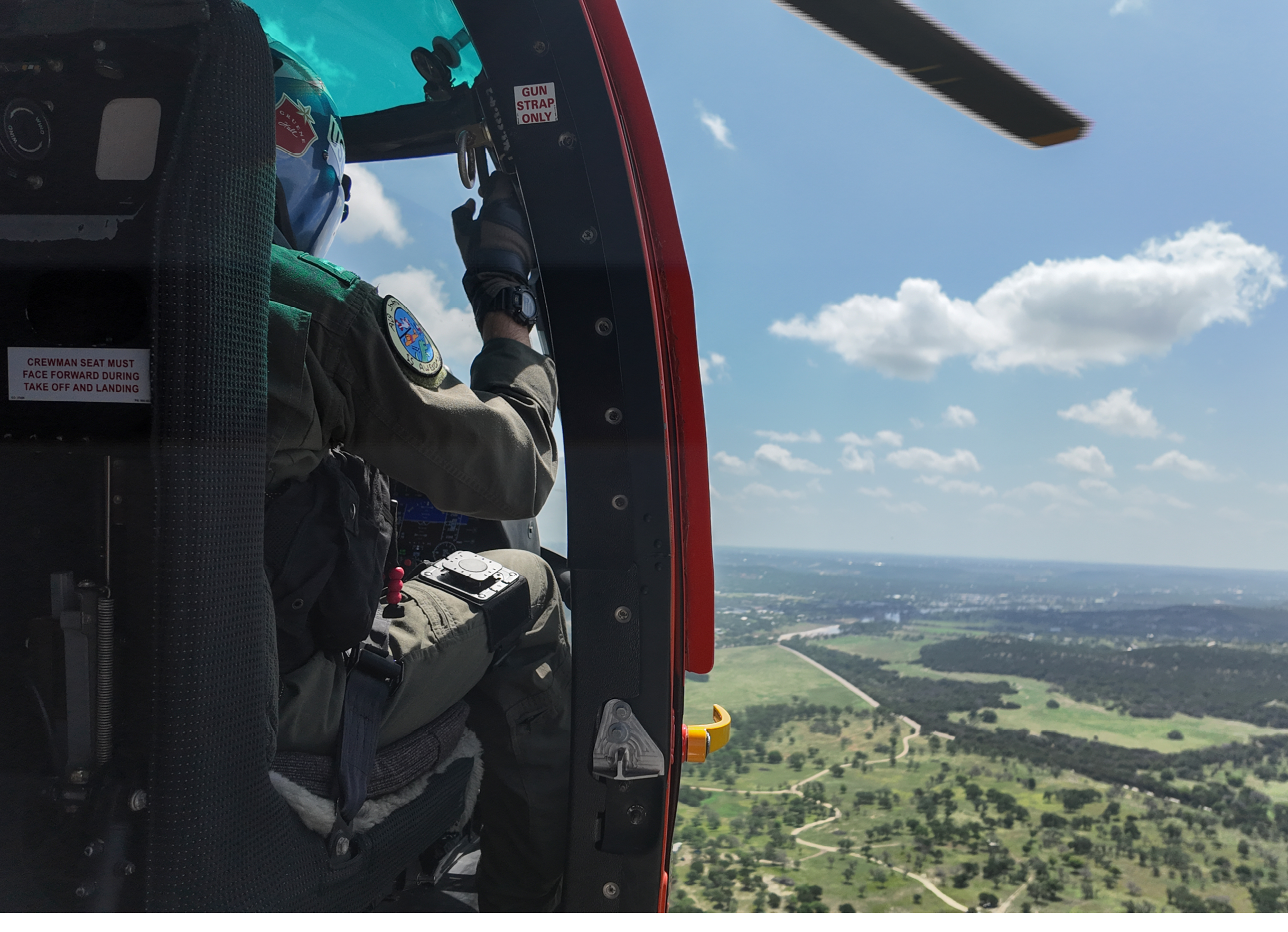 A U.S. Coast Guard MH-65 Dolphin helicopter aircrew conducts a flyover, July 10, 2025, above Kerrville, Texas. U.S. Coast Guard aircrews maintain a continuous asset presence in the wake of the catastrophic flash flooding near Kerrville. (U.S. Coast Guard photo by Petty Officer 3rd Class Carmen Caver)