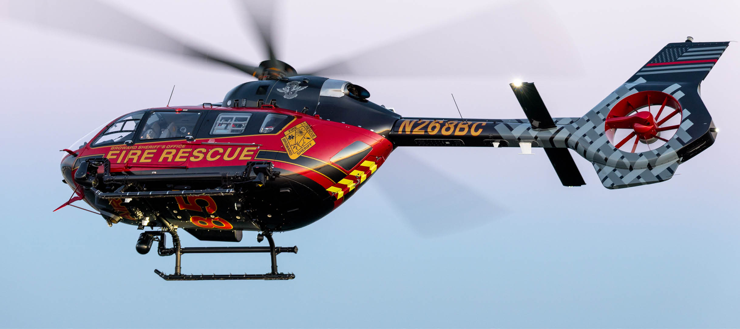 A red and yellow helicopter with the words “Fire Rescue" on the side is flying in the sky. AI generated content