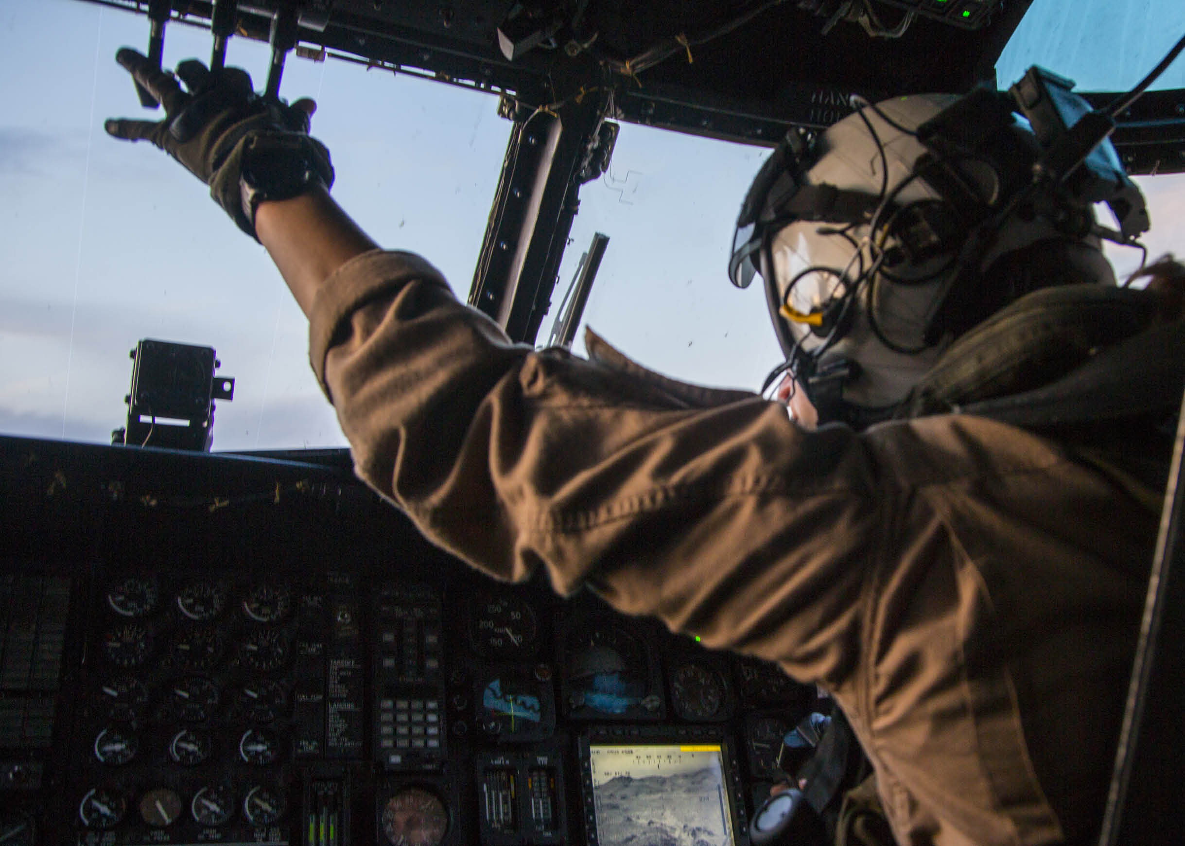 A man wearing a helmet and gloves is sitting in a cockpit of a plane. AI generated content