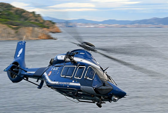 A blue helicopter is flying over a body of water. AI generated content