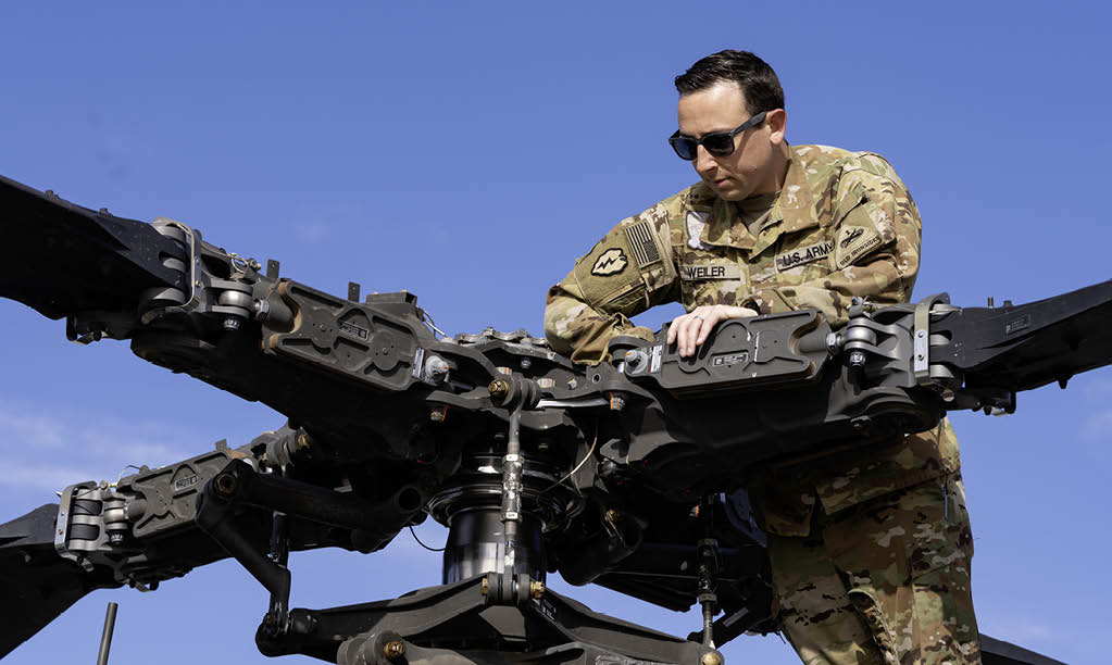 A man in a camouflage uniform is working on a helicopter. AI generated content