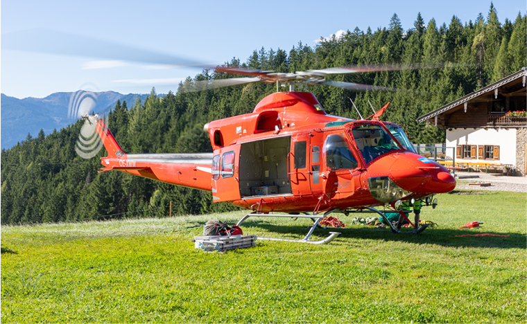 A red helicopter is parked on a grassy field. AI generated content