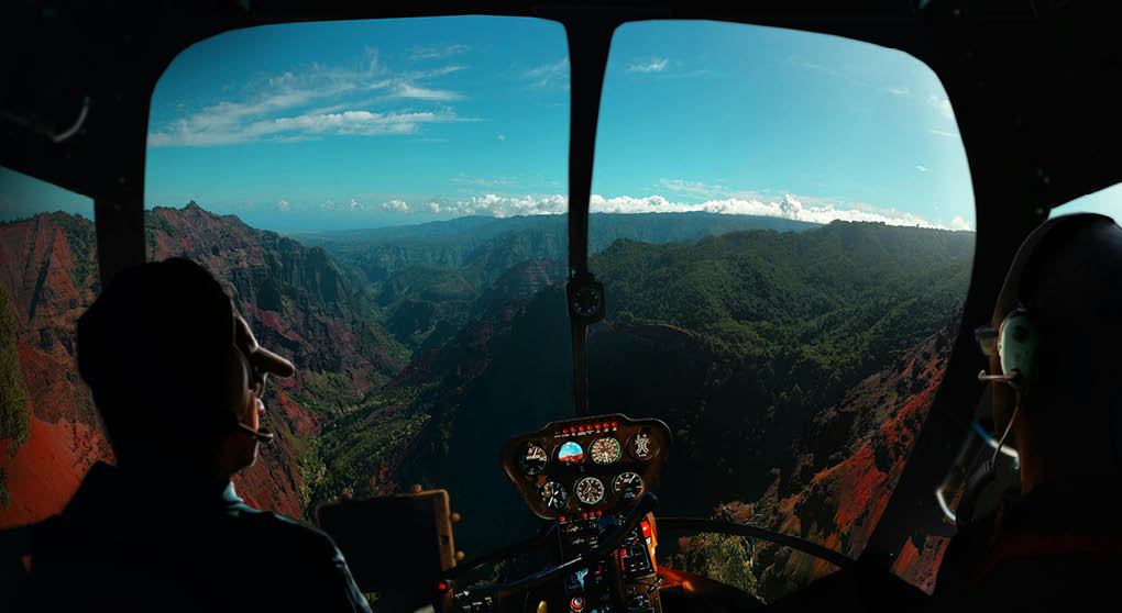 A man is sitting in a helicopter, flying over a mountain range. AI generated content