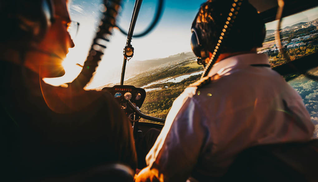 Two men are in a helicopter, flying over a beautiful landscape. AI generated content