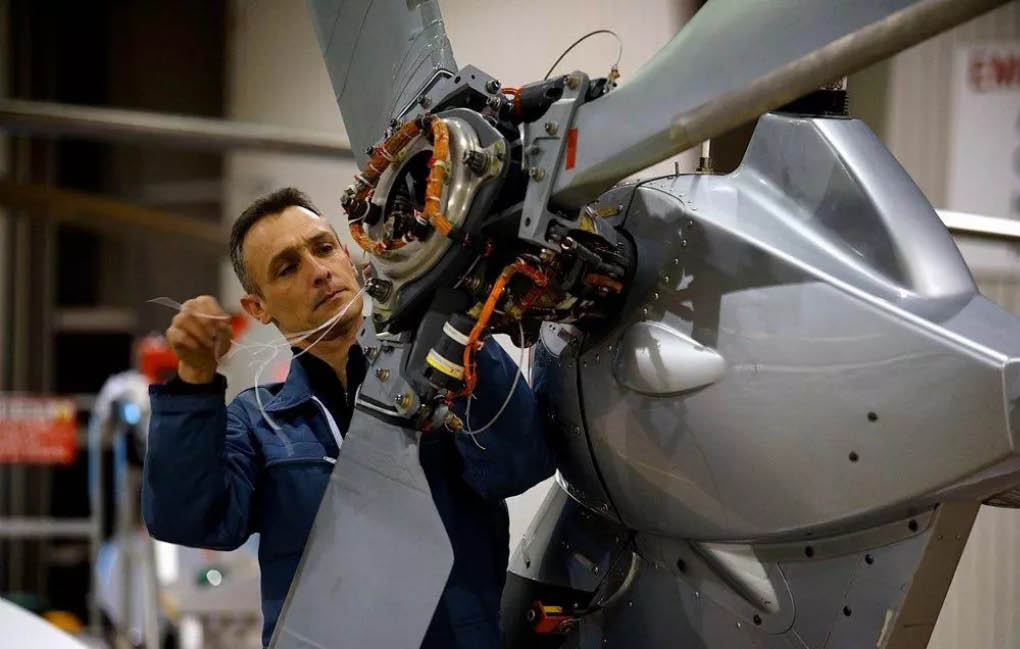 A man in a blue jacket is working on a helicopter. AI generated content