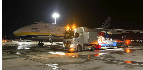 A large airplane is parked on the runway, and a truck is nearby, possibly unloading cargo. AI generated content