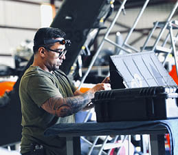 A man wearing a green shirt is working on a laptop. AI generated content