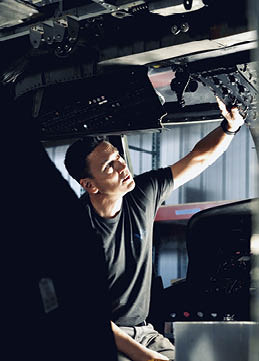A man is working on an airplane, looking at the control panel. AI generated content
