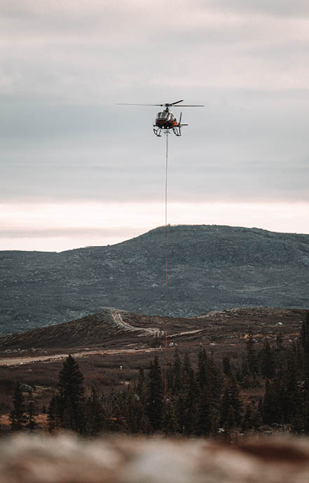 A helicopter is flying over a mountain with a person hanging from a rope. AI generated content