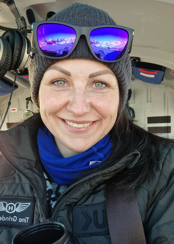 A woman wearing a black jacket and a blue scarf is holding a cup. AI generated content