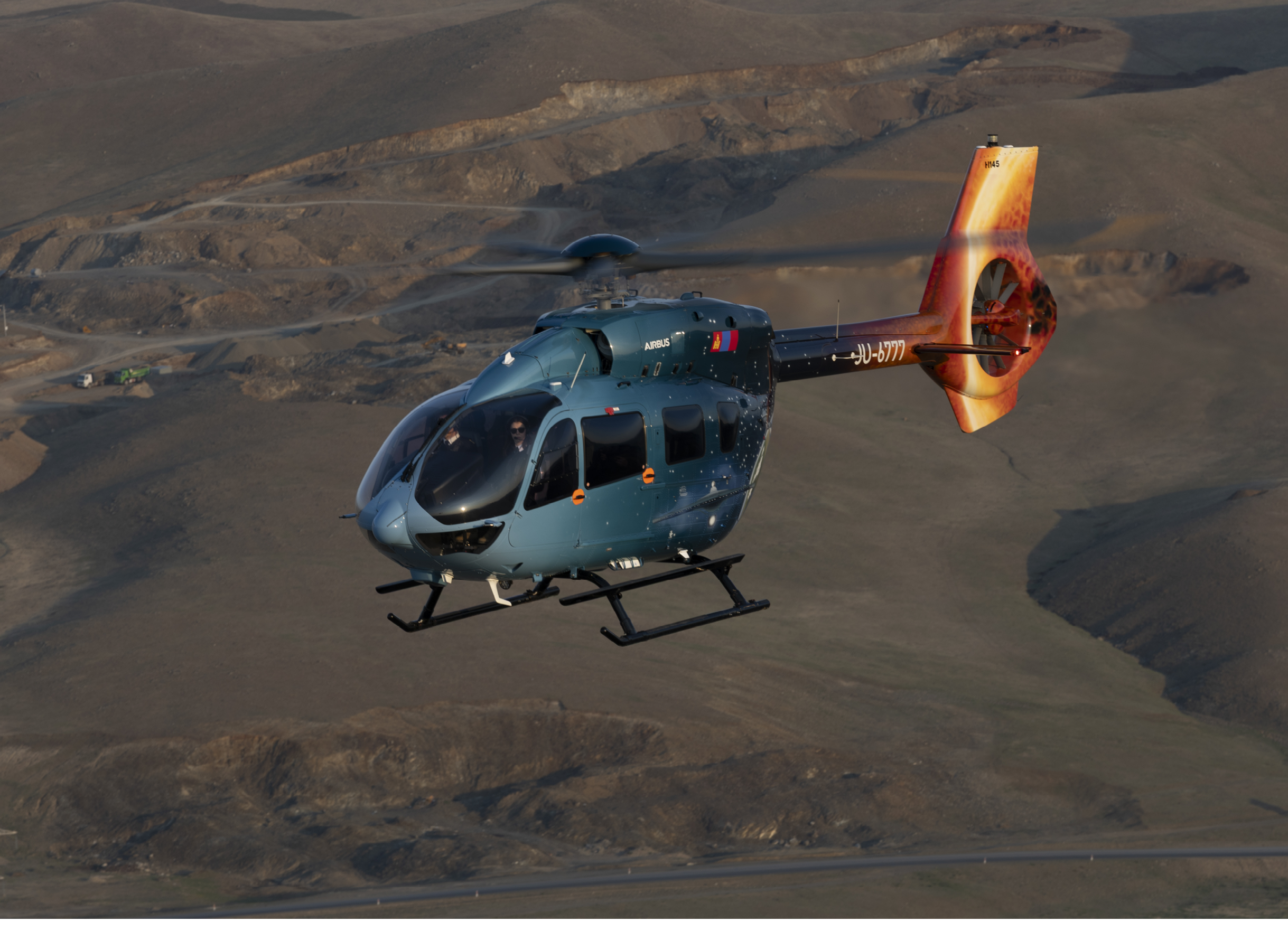 A helicopter is flying over a field with a mountain in the background. AI generated content