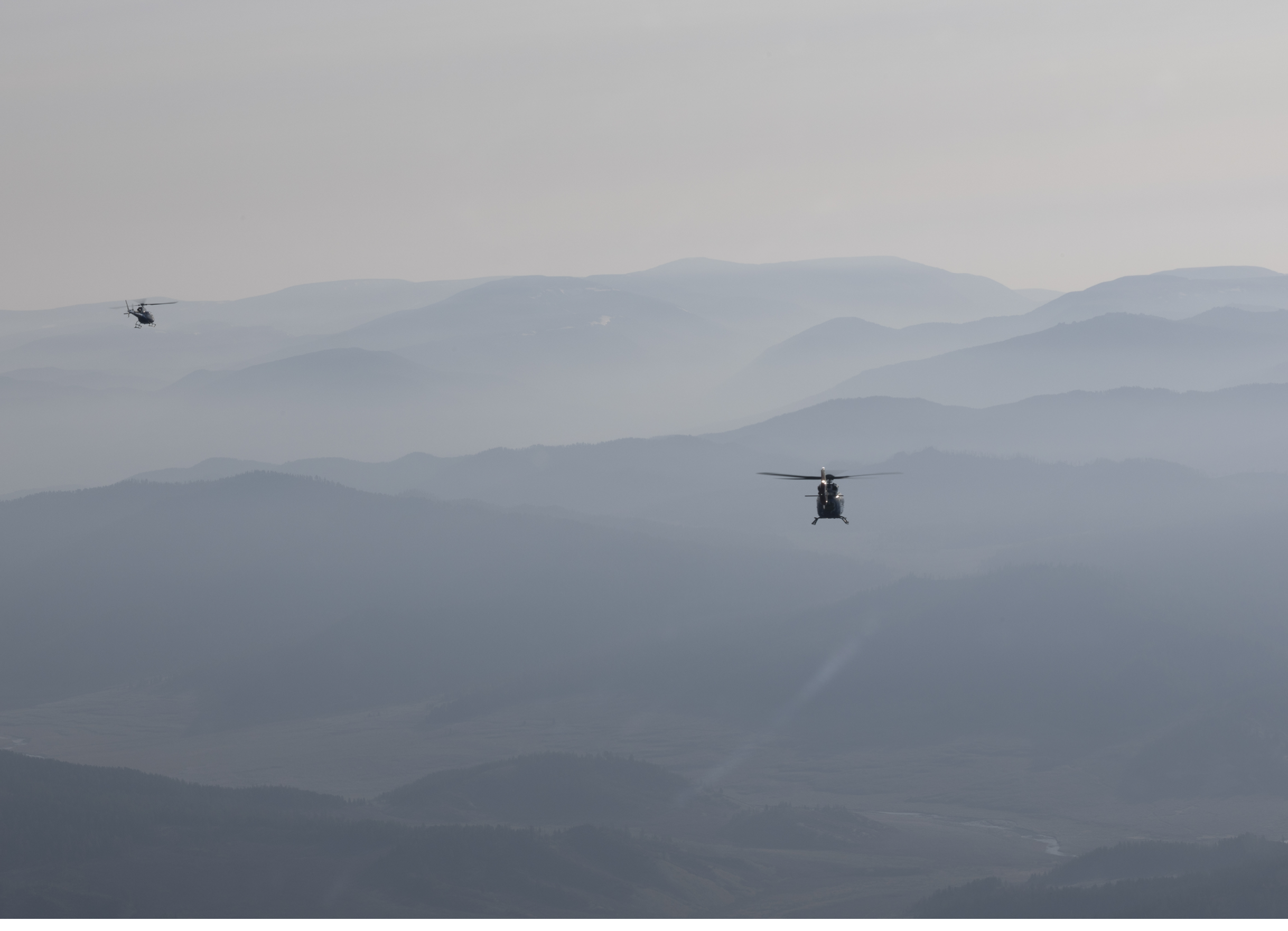 Two helicopters flying over mountains. AI generated content