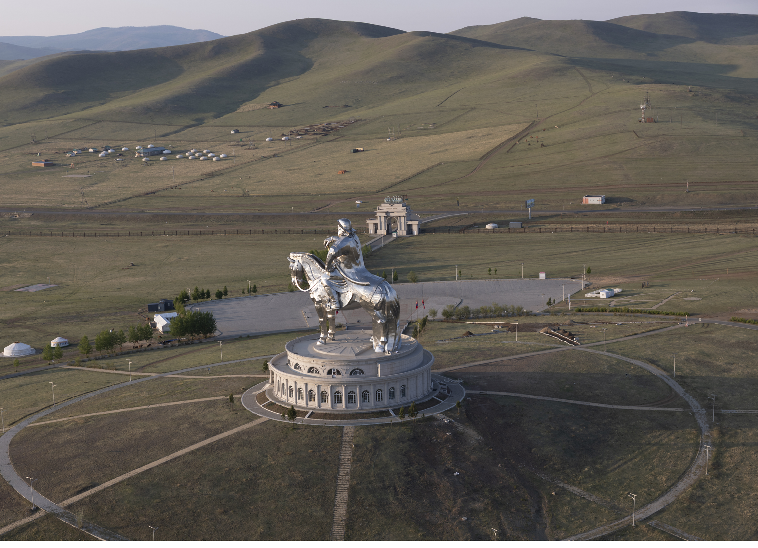 A large statue of a man riding a horse is located in a field. AI generated content