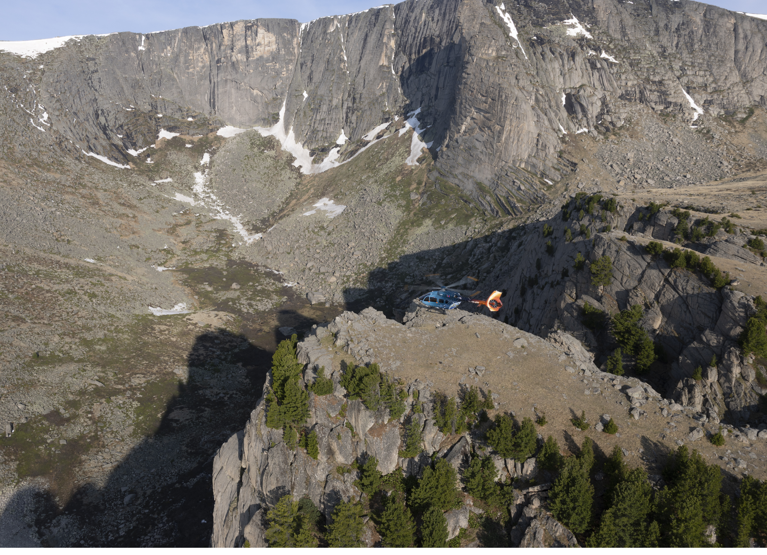 A person is standing on a rocky cliff overlooking a valley. AI generated content