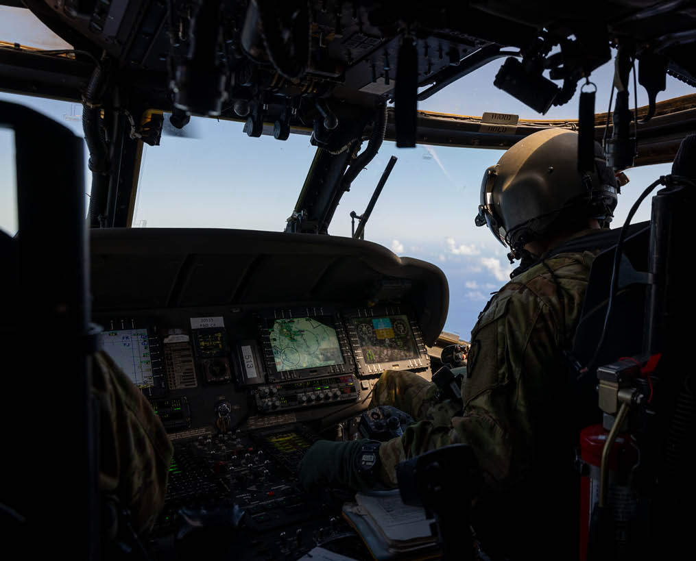 A man is sitting in a cockpit of a helicopter, wearing a helmet and a uniform. AI generated content