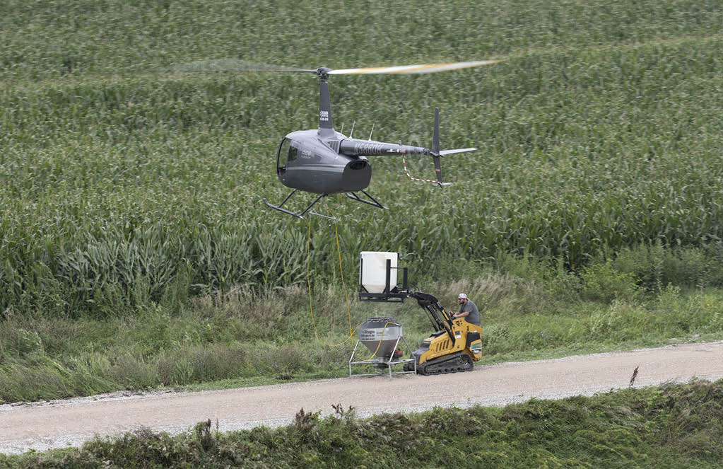 A man is working on a helicopter in a field. AI generated content