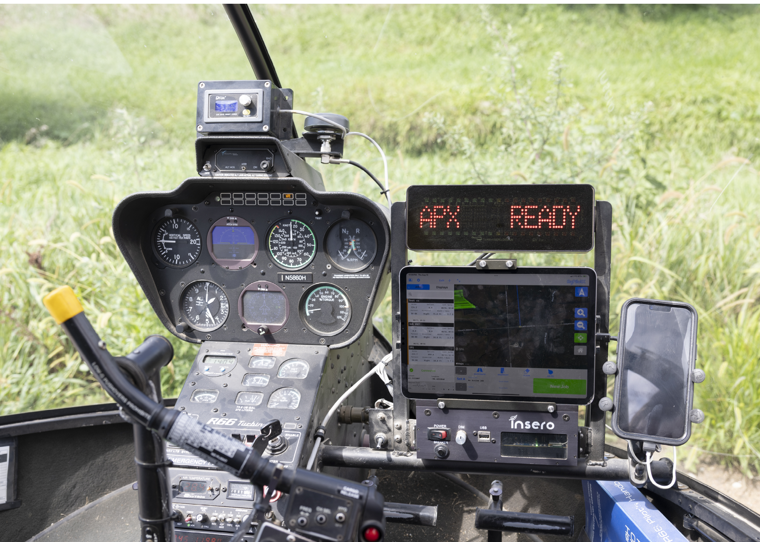 A cockpit of a helicopter with a green field outside. AI generated content