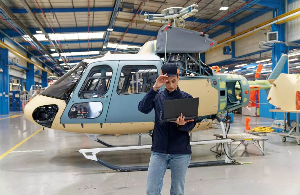 A man is standing in front of a helicopter, holding a laptop. AI generated content