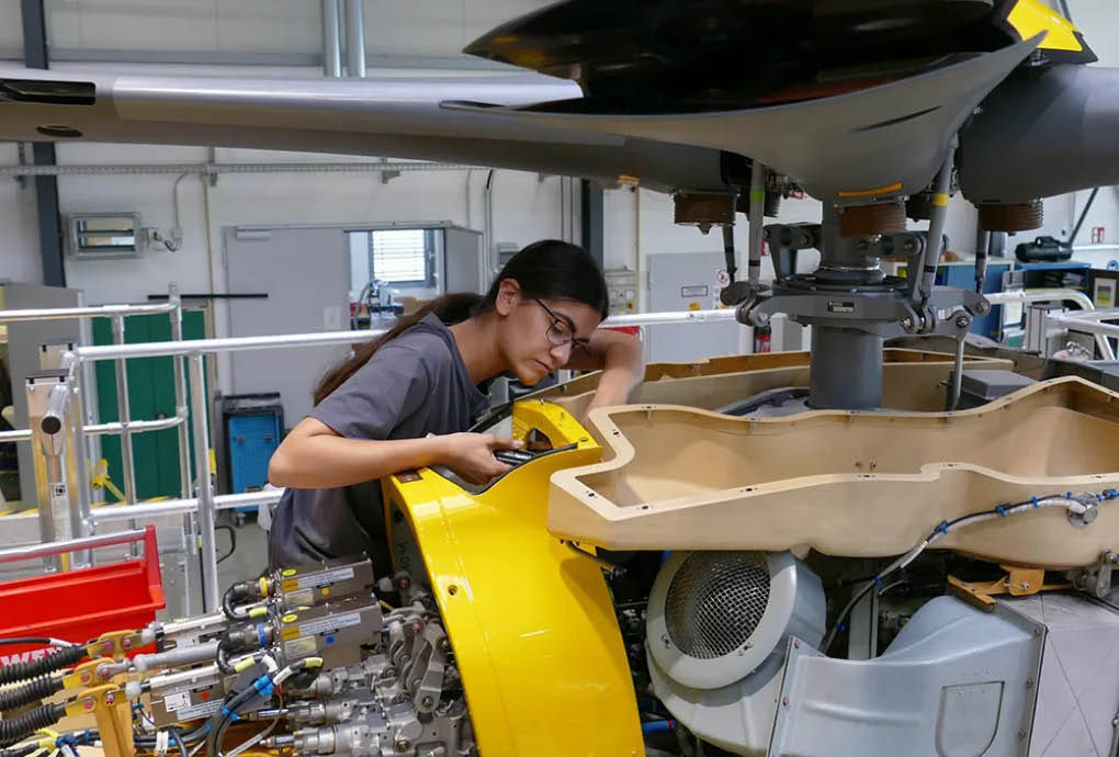 A woman is working on a small airplane in a hangar. AI generated content