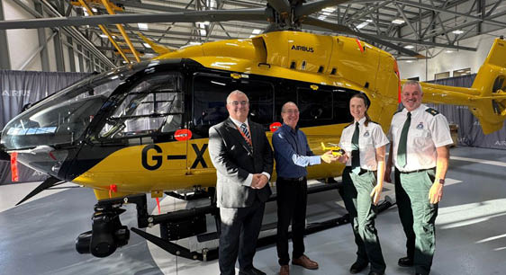 Four people are standing in front of a yellow helicopter. AI generated content